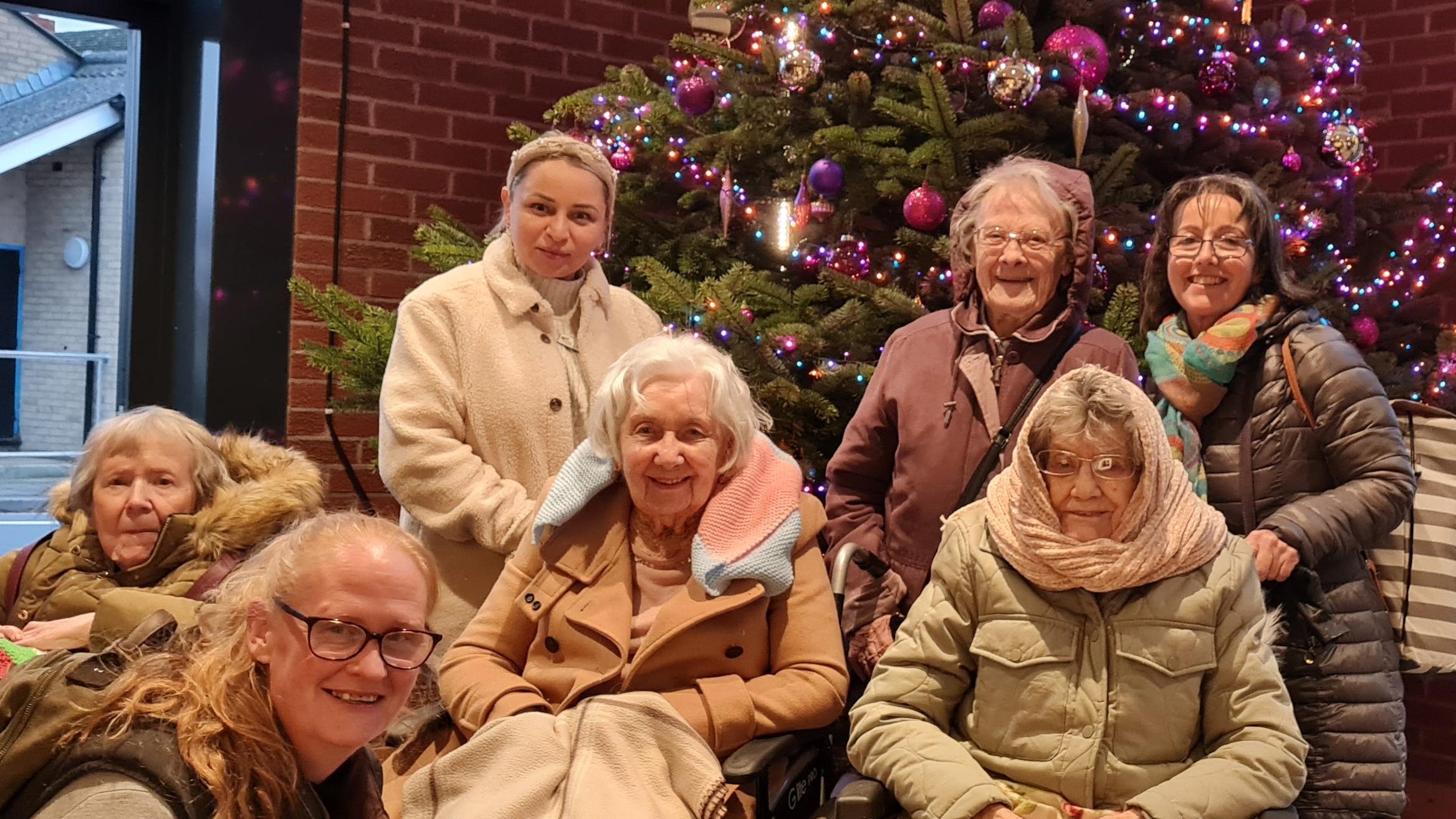 Residents and staff at the theatre in front of a Christmas tree