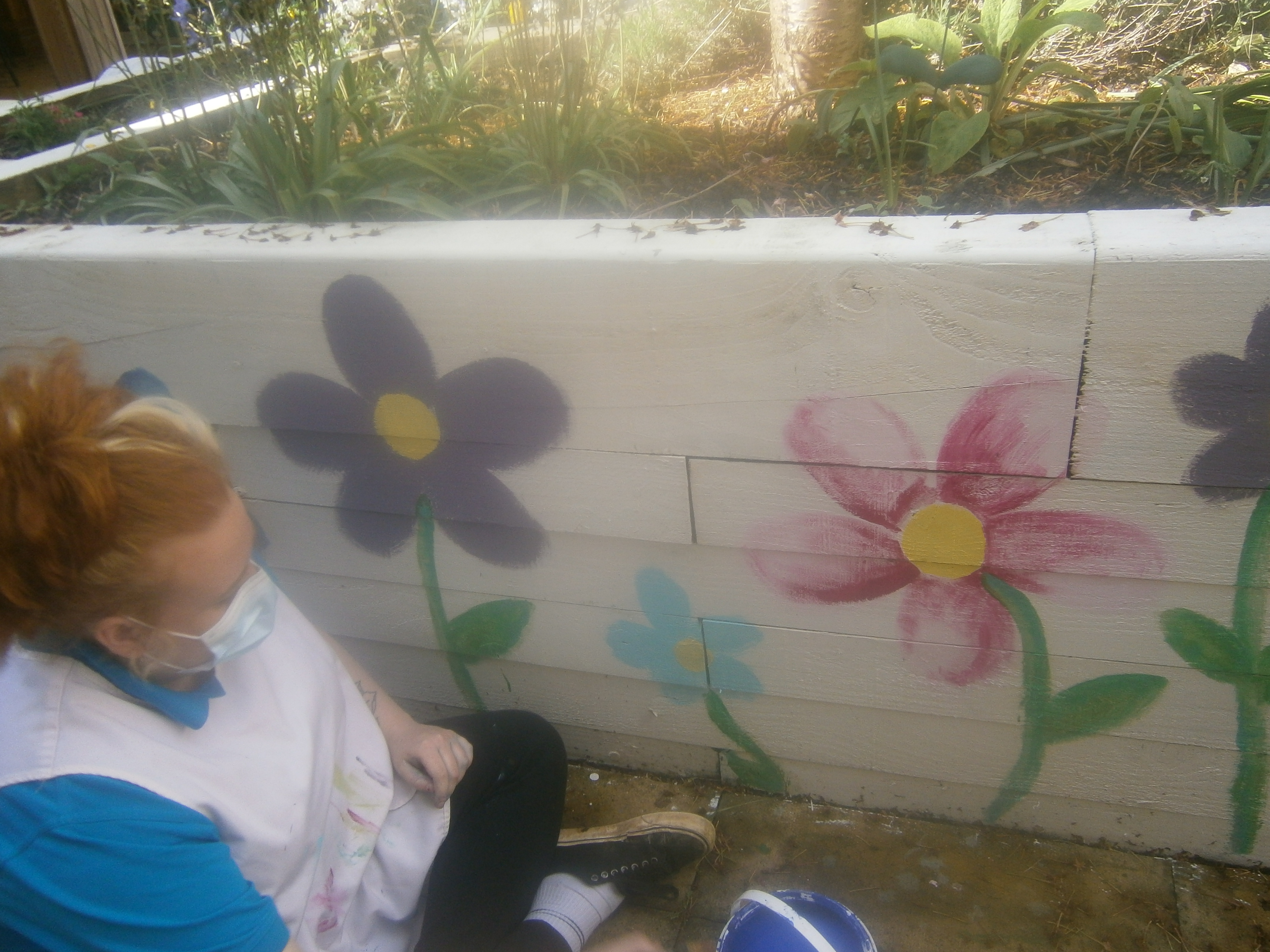 Leah painting flowers in the courtyard