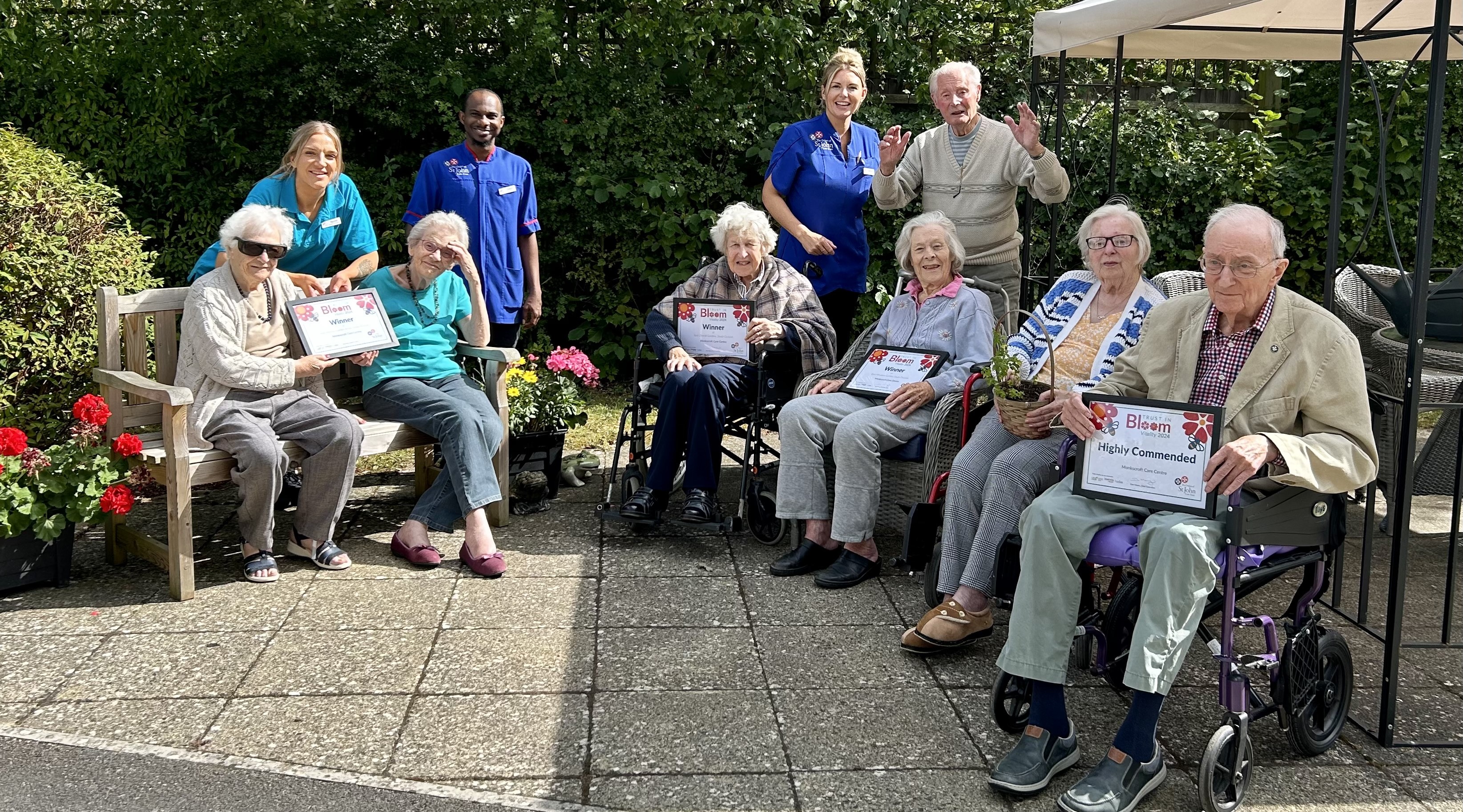 Residents and employees at Monkscroft Care Centre with Trust in Bloom certificates