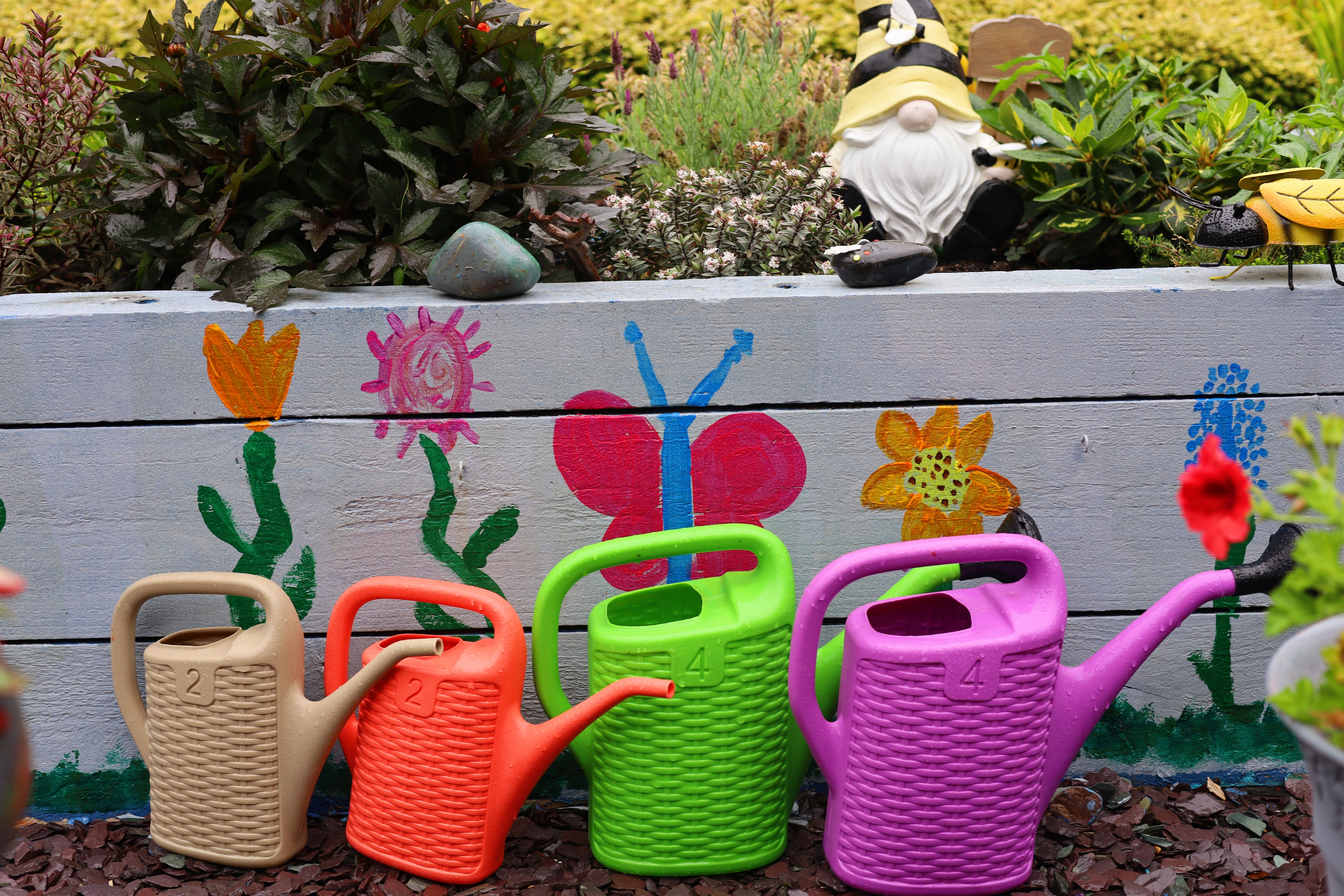 Watering cans for residents, and planters painted by local school children
