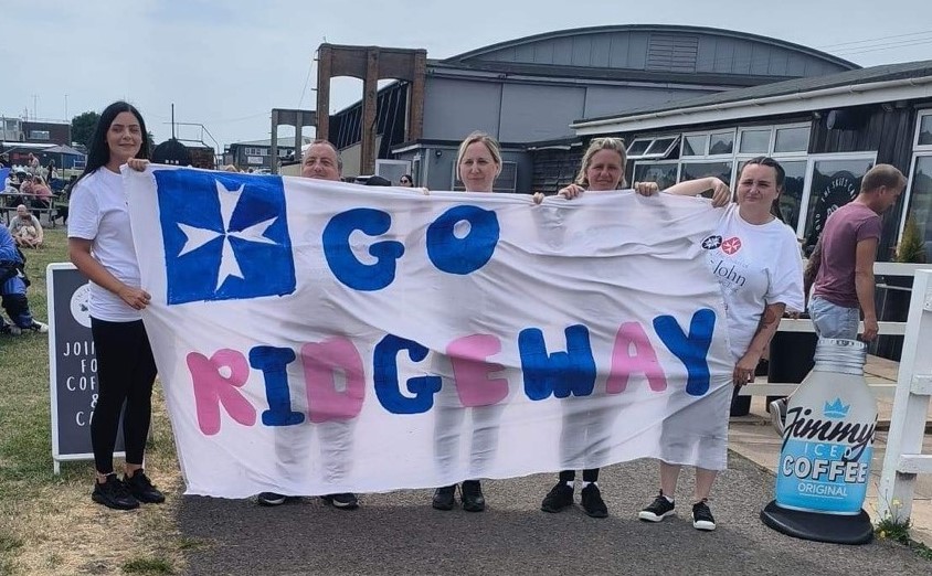 Ridgeway team holding a banner at the jump site