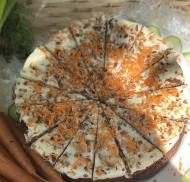 Sliced carrot cake topped with frosting and grated carrot.