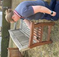 Volunteer restoring a garden bench