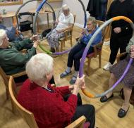 Edwardstow Court residents enjoy a seated exercise session, using large hoops to promote mobility, balance and range of motion.