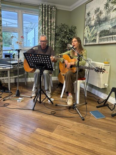 Two musicians perform an acoustic set for residents during a special afternoon of entertainment.