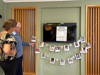 Residents looking at the Guess the Baby photo activity