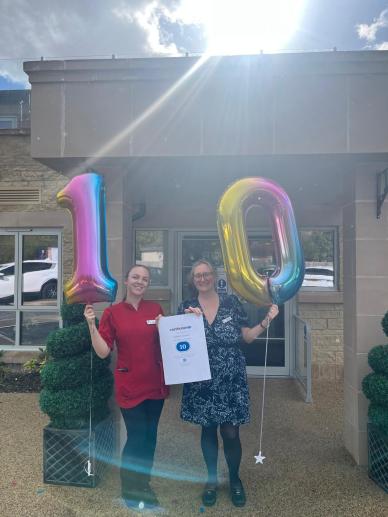 Wellford Gardens team celebrating 10 months at 10/10 on Carehome.co.uk