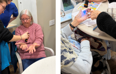 Participants using a UV light to demonstrate effective hand hygiene during Infection Prevention Week.