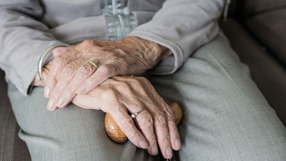 image shows hands clasped in an elderly lady's lap