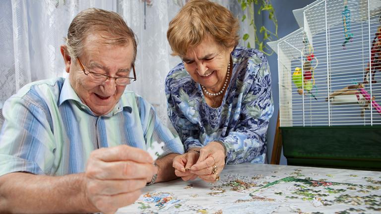 two older people doing a jigsaw