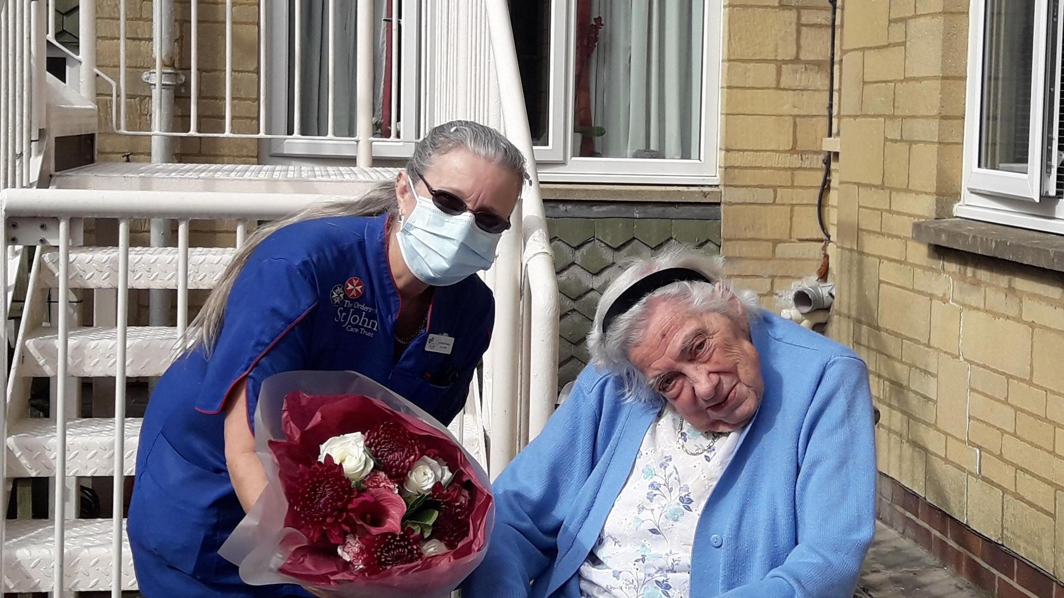 Lorraine presented with flowers by resident Margaret