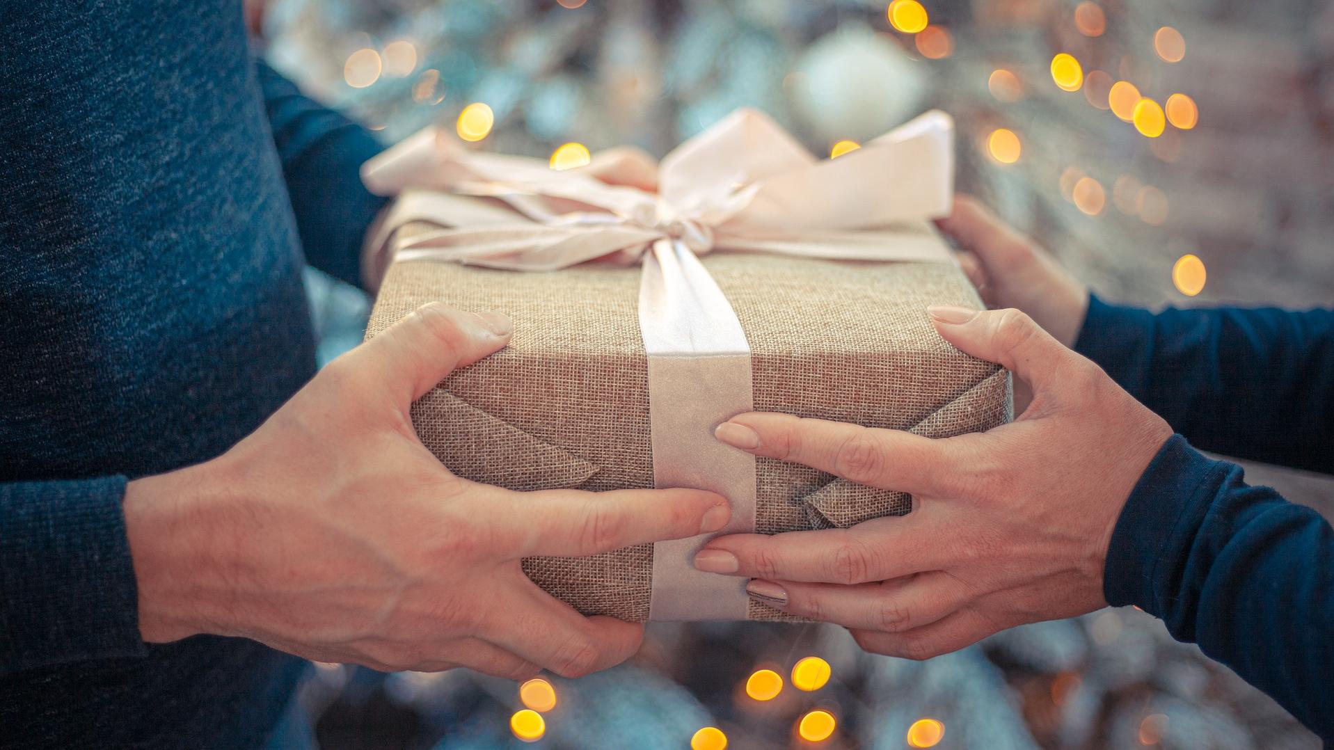 A wrapped gift being passed between two people