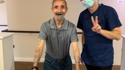 Resident Billy standing with carer