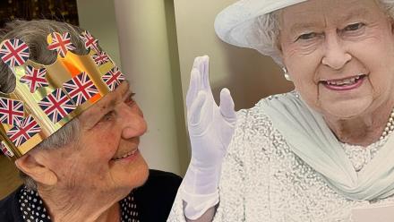 Judy wearing a crown stands beside cut-out of the Queen