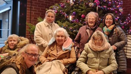 Residents and staff at the theatre in front of a Christmas tree