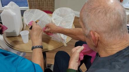 Resident and carer making a paper lantern