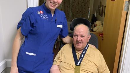 Resident Bernie tries on Alice's gold medal