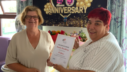 Brenda (L) receives her long service certificate from Home Manager Sara (R)